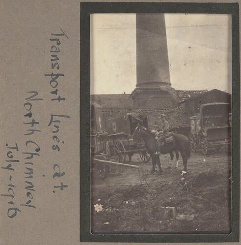 Man on horseback with three carriages and building with large brick chimney behind.