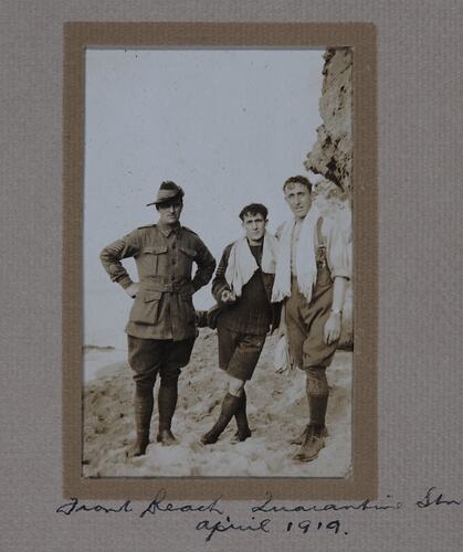 Three servicemen, two with towels around their shoulders.