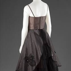 Dress with fitted brown bodice and shoestring straps, back view.