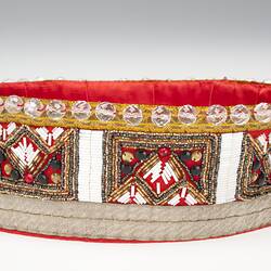 Red fabric crown decorated with clear beads and trimming.