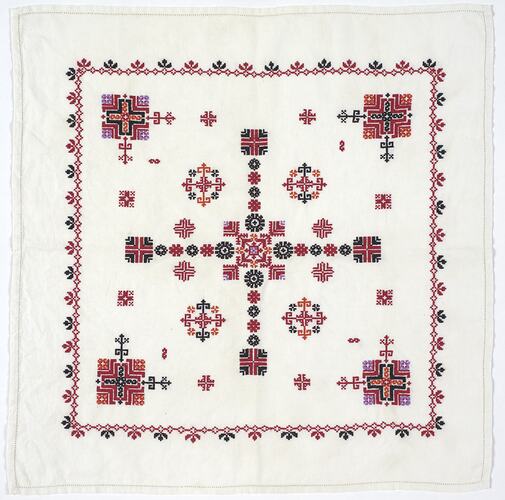 Handkerchief with red, black, and purple embroidered design.