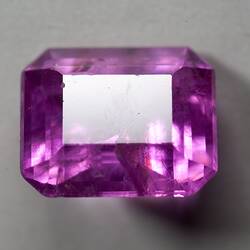 Pink, cut, rectangular gem.
