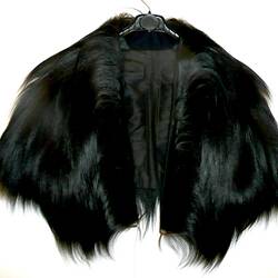 Mid-torso length cape made of black fur.