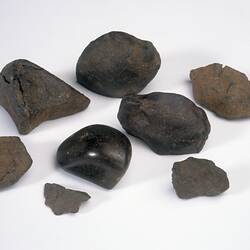 Eight meteorite specimens.