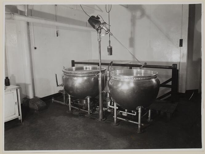 Industrial interior, dominated by two large vats.