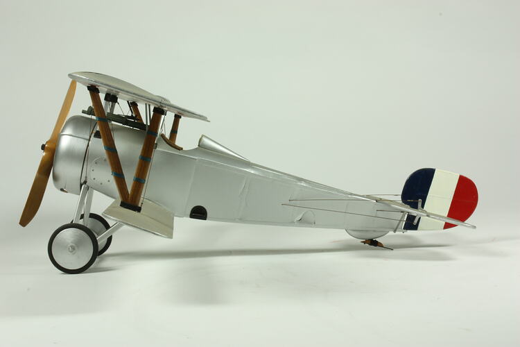Model biplane with French national colours on tail.
