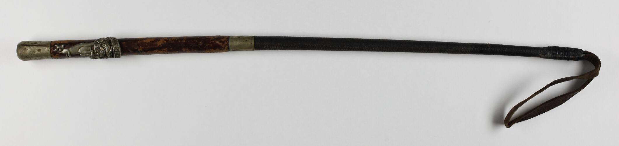 Riding crop with leather covered handle and silver detail.