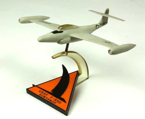 White aeroplane model on white and orange stand.