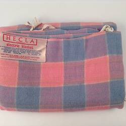 Folded electric blanket with check pattern.