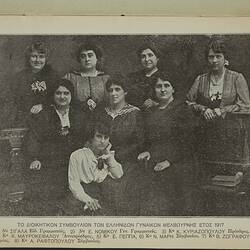 Eight women pose. Four stand behind three seated women whilst one woman kneels at front. Printed names below.