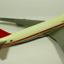 White model plane with red trim and tail. Grey wings. Right rear three quarter view.