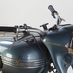 Blue metallic motor cycle. Tank, handle bars and dash detail, front right view.