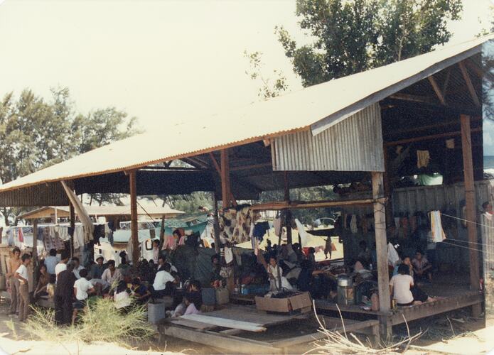People under gable-roofed shelter with no walls.
