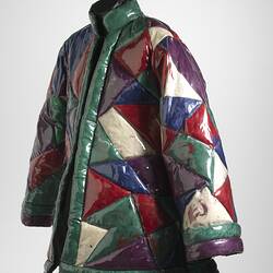 Angle view of quilted geometric plastic jacket filled with coloured feathers. Quilted sections are triangular.