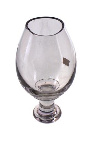 Partially formed body and stem of a wine glass. Made of clear glass. The rim is jagged.