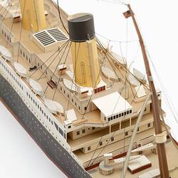 Cardboard model of passenger steamship. Detail of two funnels, black hull and American flag on rigging.