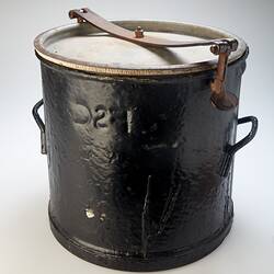 Black metal bucket with lid and a handle on each side. Metal clip holds down lid.