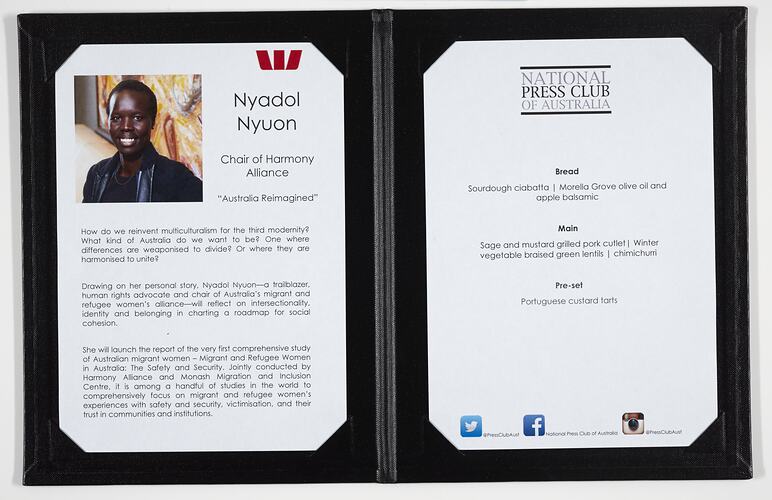 Open black menu with two white pages. Photograph and text on left, text only on right.