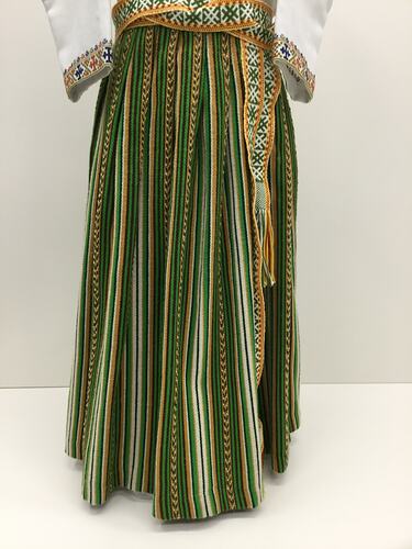 Green and brown patterned long pleated skirt. Woven belt.