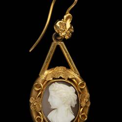 Gold mounted cameo earring. Round white cameo profile bust with brown background, gold border.