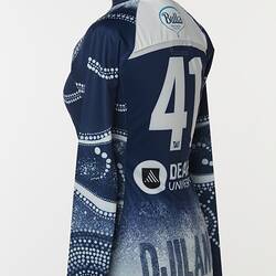 Back of women's AFLW guernsey with Indigenous pattern in navy and white. Lined and dotted design.