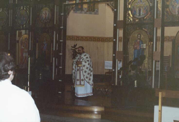 Religious father wearing an ornate white and gold stole during a religious ceremony.