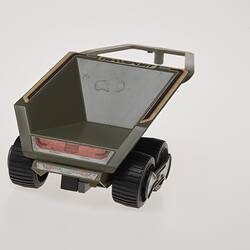 Plastic grey toy trailer with two wheels. Back view.