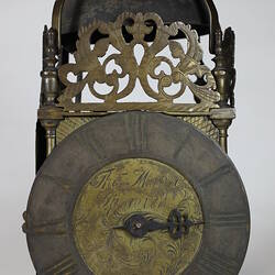 Rectangular metal clock with domed top, front view.