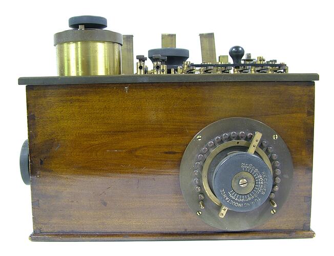 Machine with metal parts in a wooden box.
