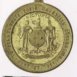 Round gold coloured medal with coat of arms, text surrounding.