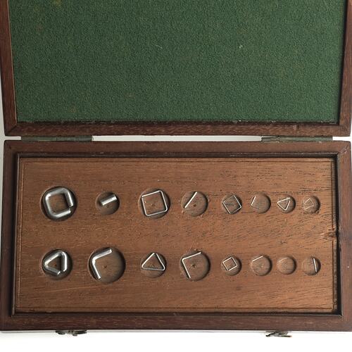 Sixteen standard grain weights, gilt brass and platinum wire weights in wooden box. Green lined lid.