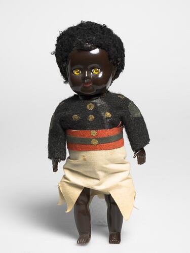 Fijian policeman doll in uniform. Navy long sleeved shirt, white sulu and red/black belt.