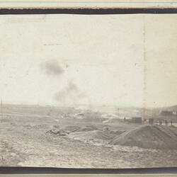 Landscape with smoke in centre, groups of soldiers and small structures on right.