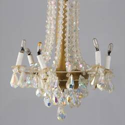 Crystal effect chandelier with six arms.