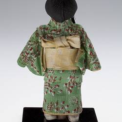 Back view of robed doll on mount.