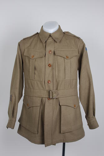 Khaki military woollen tunic coat with four pockets, buttons and belt.
