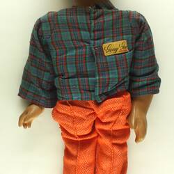 Ventriloquist doll with a green shirt and orange pants.