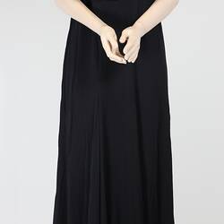 Front view, long black dress with elbow sleeves.