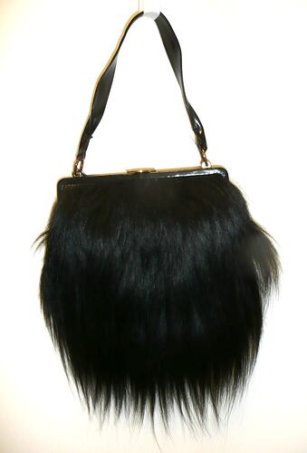 Handbag covered in long, black fur.