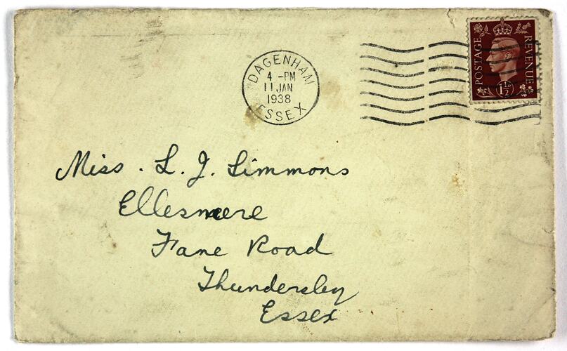Off white envelope with handwritten text. Stamped and postmarked.