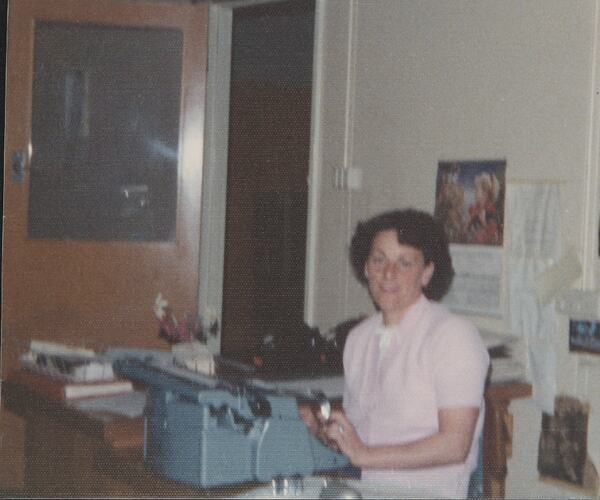 Woman seated at typewriter.