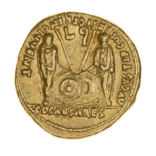 Round coin, aged, two figures, facing forwards, two shields on ground between them, with spears on top.