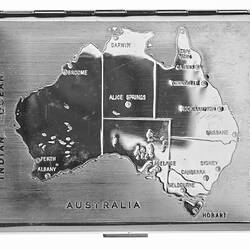 Silver metal cigarette case with etched outline map of Australia on lid.
