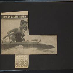 Album page with newspaper photograph, black and white, two women on surf ski.