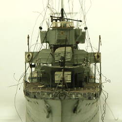 Grey coloured naval ship, front view.