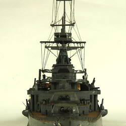 Naval ship with two masts, front view.