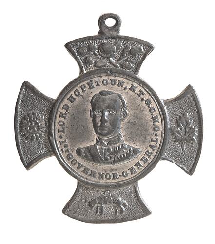 Crossed shaped medal with male bust at centre and lettering around.