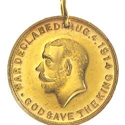 Medal with man facing left, text around.