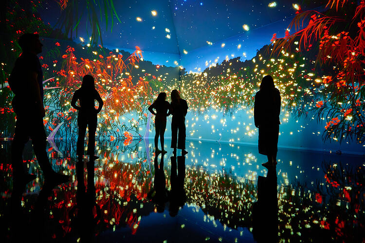Four people in silhouette against a colourful background.
