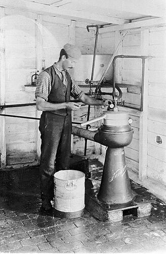 [Charles Pettaval separating milk with a mechanical milk separator, Budgeree, Gippsland, 1910. Cream separated from milk was used to make butter.]